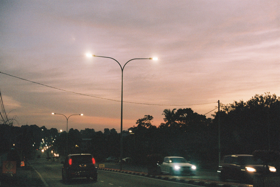 Malaysian highway traffic at dusk with car headlights during festive balik kampung journey