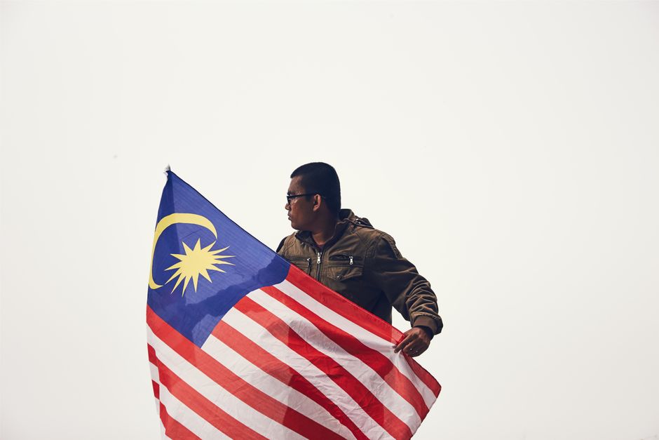 Merdeka Malaysia flags waving on highway road trip blue sky August