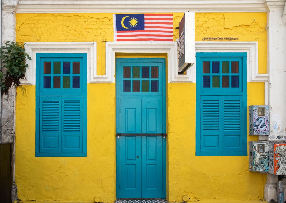 Perodua Myvi Gen 3 parked on Malaysian street with tropical urban shophouses background