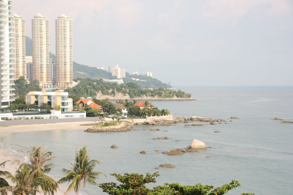 Batu Ferringhi beach strip Penang coastal road palm trees hotels golden hour